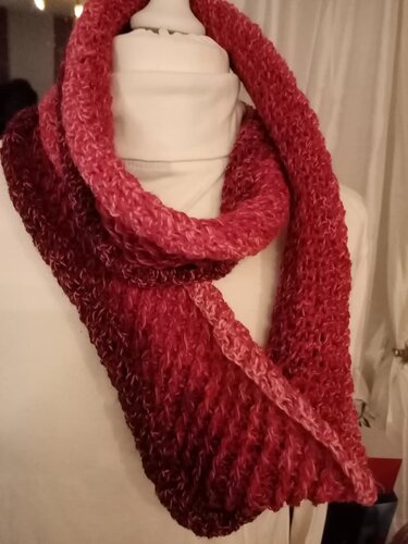 Gehäkelter Loop-Schal in Rot- und Rosatönen auf Büste