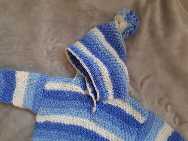 gestrickter Babypullover mit Kapuze und Bommel in blau-weißen Streifen