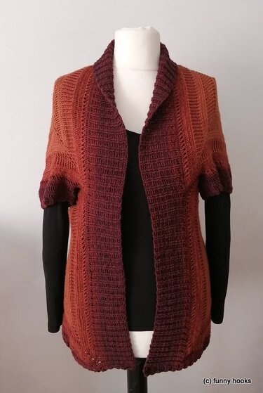 Gehäkelter, hüftlanger Seelenwärmer in Rost- und Burgundtönen mit breitem Schalkragen auf Schaufensterpuppe