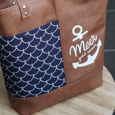 Braune Tasche mit dunkelblauem Muschelmuster und weißem Anker-Plott „Meer geht immer“