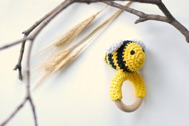 Handgehäkelte Biene auf Holzring, gelb-schwarz gestreift mit weißen Flügeln