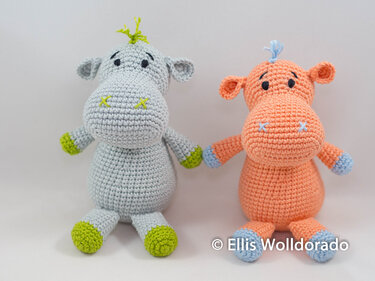 Zwei gehäkelte Amigurumi-Nilpferde, hellgrau mit limette und apricot mit blau