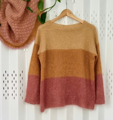 Gestreifter Pullover mit Rundhals in Creme, Karamell und Altrosa an einem Holzbügel