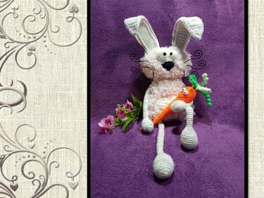 Gehäkelter weißer Hase mit Schlappohren und orangefarbener Möhre auf violettem Hintergrund