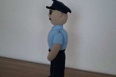 Gehäkelte Amigurumi-Puppe in Polizeiuniform, seitliche Ansicht