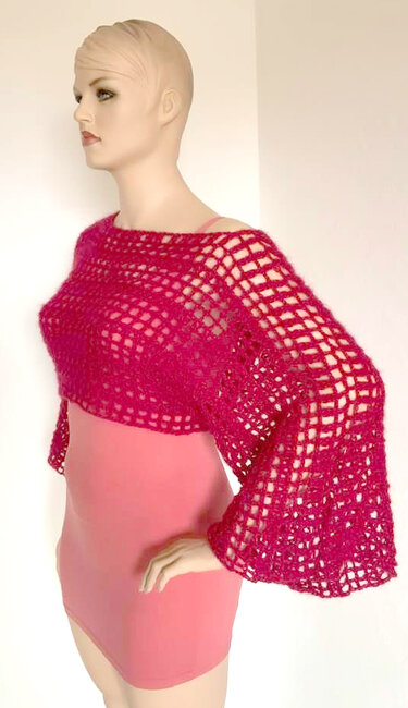 Fuchsiafarbener, kurz gehäkelter Poncho mit Gittermuster und weiten Ärmeln über rosa Figurkleid auf Schaufensterpuppe