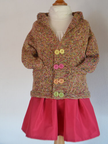 Handgestrickte Kinderstrickjacke mit Kapuze, Taschen und bunten Knöpfen auf Schaufensterpuppe