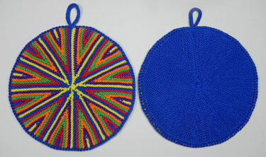 Zwei runde gestrickte Topflappen, links bunt radial gestreift, rechts einfarbig blau, beide mit Schlaufe zum Aufhängen