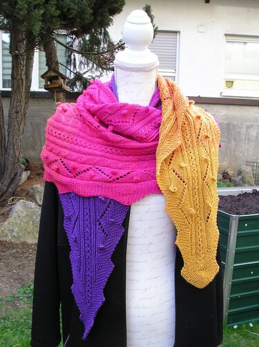Mannequin trägt dreieckiges Drachenschwanz-Tuch in Pink, Violett und Senfgelb mit Lochreihen und Noppen