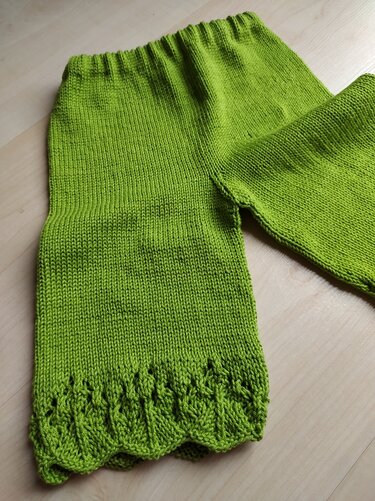 Gestrickte grüne Babyhose mit elastischem Bund und dekorativer Lochkante