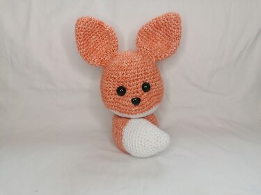 Orange-weißes gehäkeltes Fuchs-Amigurumi mit großen Ohren und schwarzen Augen