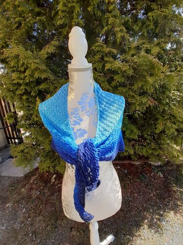 Gehäkeltes blaues Dreieckstuch auf Schneiderpuppe, vorne locker geknotet