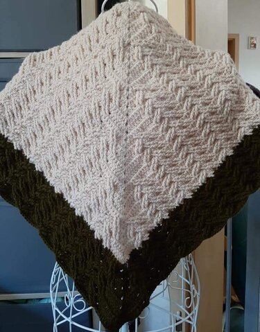 Beiges gehäkeltes Dreieckstuch mit olivgrünem Rand auf einer Schneiderbüste