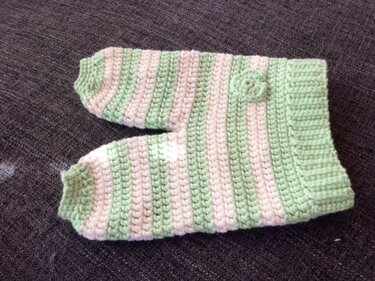 Gehäkelte Babyhose mit breitem Bündchen und Blütenapplikation