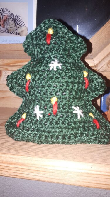 Kompakter schnell gehäkelter Weihnachtsbaum in Dunkelgrün mit roten, gelben und weißen Stickakzenten