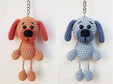 Zwei gehäkelte Hunde-Schlüsselanhänger in Pfirsich und Hellblau an Metallketten