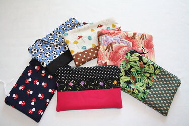 Mehrere kleine genähte Täschchen mit unterschiedlichen Mustern und Farben, auf hellem Untergrund angeordnet