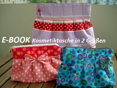 Drei Kosmetiktaschen: lila mit Punkten, rosa mit Schleife und blau mit Kreisen auf Holztisch