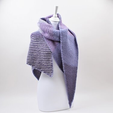 Asymmetrical triangular knitted scarf with a striped wedge displayed on a mannequin