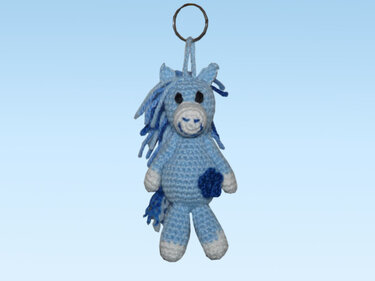 Gehäkelter blauer Pferde-Schlüsselanhänger (Amigurumi) mit dunkler Mähne, weißer Schnauze und Hufen an Metallring.