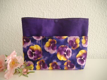 Dunkellila Stoffutensilo mit violett-gelbem Stiefmütterchen-Motiv und sichtbaren Außentaschen