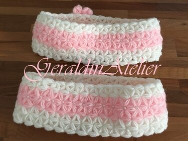 Zwei gehäkelte rosa-weiße Stirnbänder mit sternförmigem Muster, eines mit kleiner Schleife