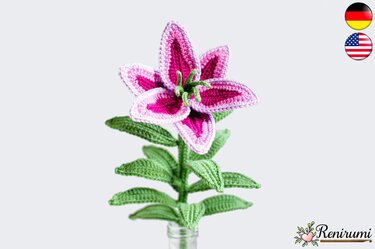 Pink crocheted lily flower with green stem and leaves on pale background