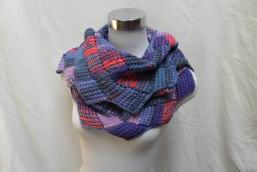 Mehrfarbiger gehäkelter Loop-Schal in Blau, Violett und Koralle auf Büste drapiert