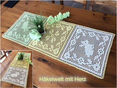 Gehäkelter Filet-Tischläufer aus drei verbundenen Quadraten mit Hasen- und Blumenmotiven in Pastellfarben auf Holztisch