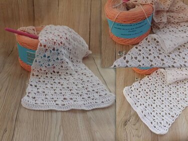 Cremeweißer Häkel-Tischläufer mit Spitzendesign, teils aufgerollt, neben Garnknäuel und Häkelnadel