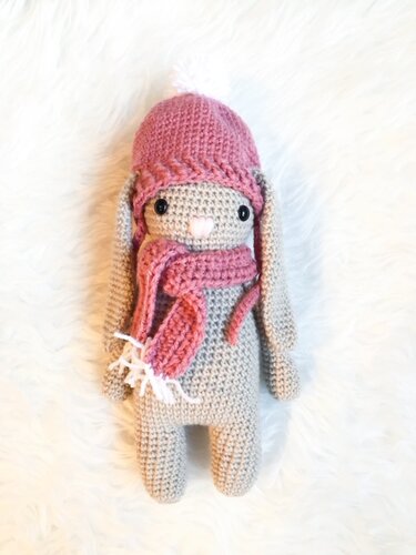 Gehäkelter Amigurumi-Hase in Grau mit rosa Mütze und Schal
