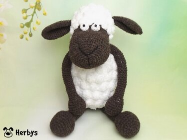 Gehäkeltes Amigurumi-Schaf braun-weiß sitzend mit gesticktem Gesicht