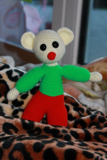 Amigurumi-Maus in Grün und Rot auf Leopardenmuster