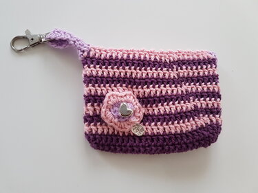 Gehäkeltes Täschchen in Rosa und Violett mit Karabinerhaken und Blütenapplikation