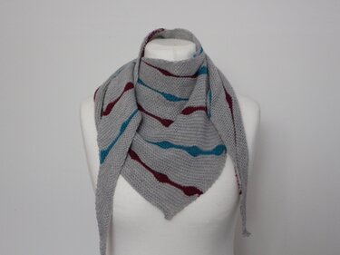 Gestricktes graues Dreieckstuch mit türkisen und bordeauxfarbenen Wellenstreifen auf weißer Schaufensterpuppe