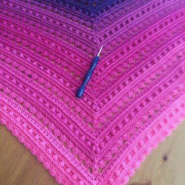 Gehäkeltes Dreieckstuch Lila‑Pink mit Relief- und Noppenmuster und Häkelnadel
