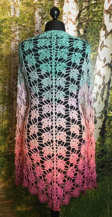 Back view of a crocheted ombre triangle shawl on a mannequin, mint-to-pink gradient with leaf-lace openwork.
