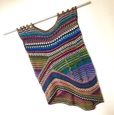 Multicolor striped knitted sleeveless tunic with scoop neckline hanging on a rod