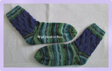 Handgestrickte Socken in Blau- und Grüntönen mit Zopf- und Streifenmuster