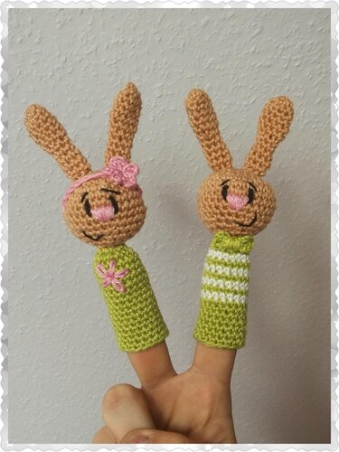 Zwei gehäkelte Hasen-Fingerpuppen mit langen Ohren, grün-beigen Körpern und rosa Details
