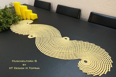 Yellow crocheted wavy table runner with concentric shell motifs on a dark dining table beside yellow candles and greenery