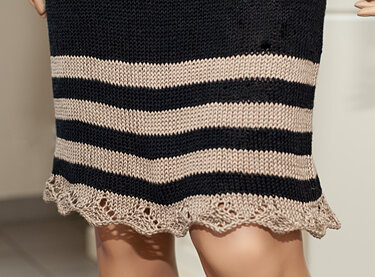 Unterer Bereich eines gestrickten Kleides mit dunklen und beigen Streifen und gewelltem Muschelsaum
