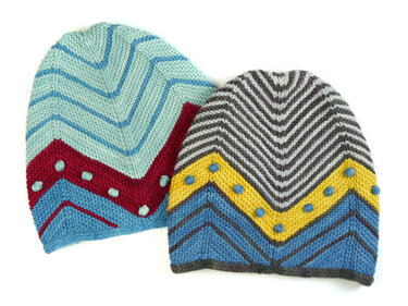 Two colorful knitted hats with chevron stripes and bobble accents; one in blue and red tones, the other in gray, yellow and blue.