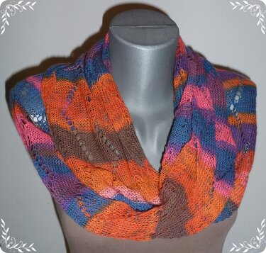 Mehrfarbiger gestrickter Loop‑Schal mit Lochmuster auf einer Schaufensterpuppe