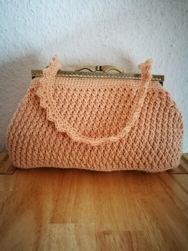 Gehäkelte pfirsichfarbene Clutch mit Metallrahmen und kurzem Tragegriff