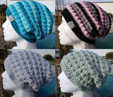 Vier gehäkelte Slouchy‑Mützen auf Schaufensterpuppenköpfen in türkis, schwarz‑pink, hellgrau und mintgrün.