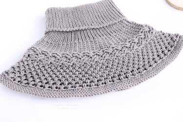 Nahaufnahme eines gehäkelten Kragenschals mit Rippenkragen, Zopf- und Netzmuster