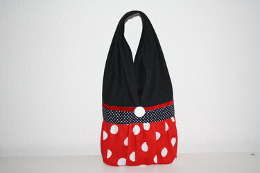 Stofftasche mit schwarzem Oberteil, gepunktetem Taillenband, rotem Unterteil und weißem Knopf