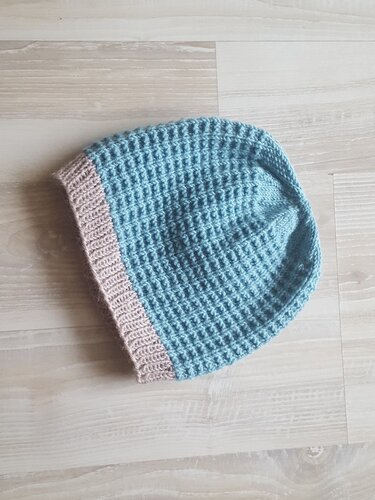 Gestrickte Babymütze hellblau mit beigem Rippbündchen, flach ausgelegt