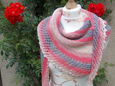 Gestricktes Dreieckstuch in Rosa-, Grau- und Beigetönen mit Streifen und Lochmuster auf einer Schneiderpuppe.